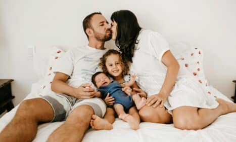 Happy family relaxing and enjoying quality time on a cozy bed, expressing love and togetherness.