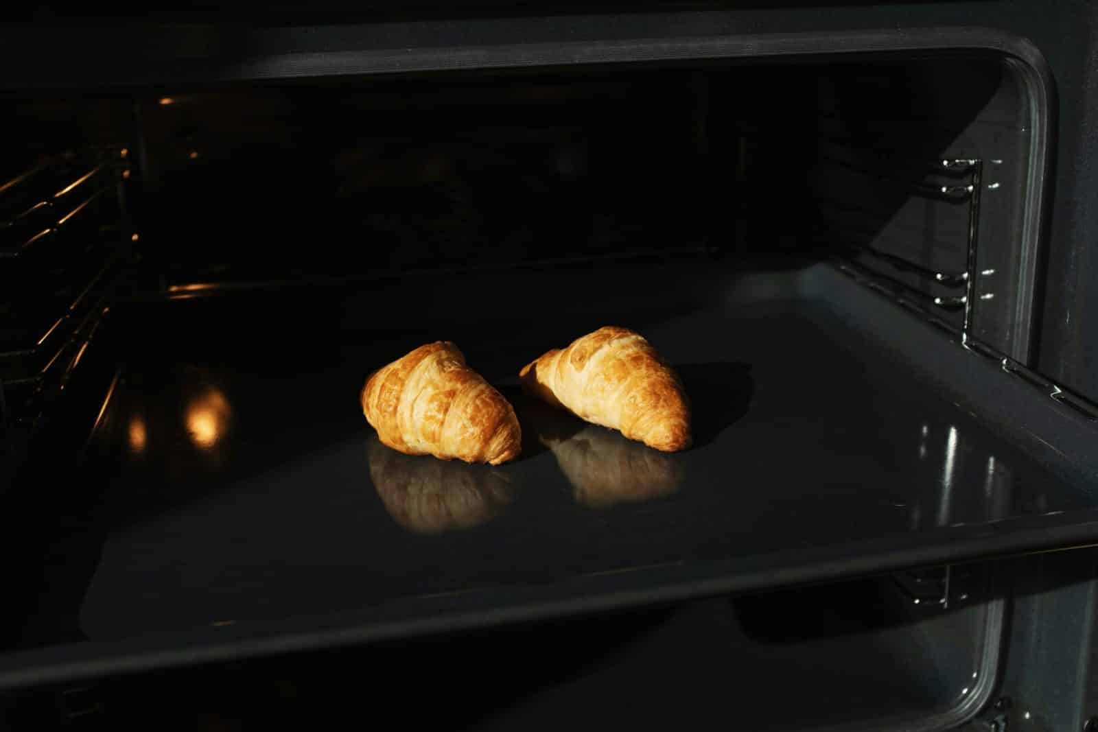 Golden croissants baking in an oven, capturing the perfect homemade pastry moment.