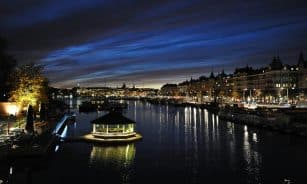 Beautiful nighttime view of Stockholm's waterfront with illuminated cityscape and reflections.