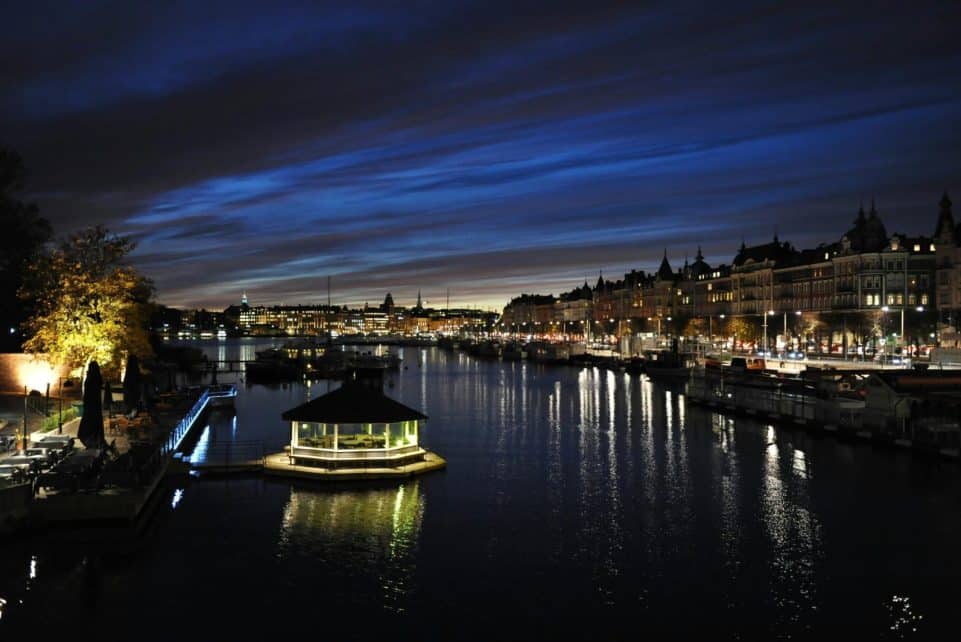 Beautiful nighttime view of Stockholm's waterfront with illuminated cityscape and reflections.