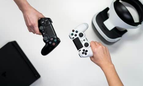 Black and white gaming controllers with VR headset on a minimalist background.