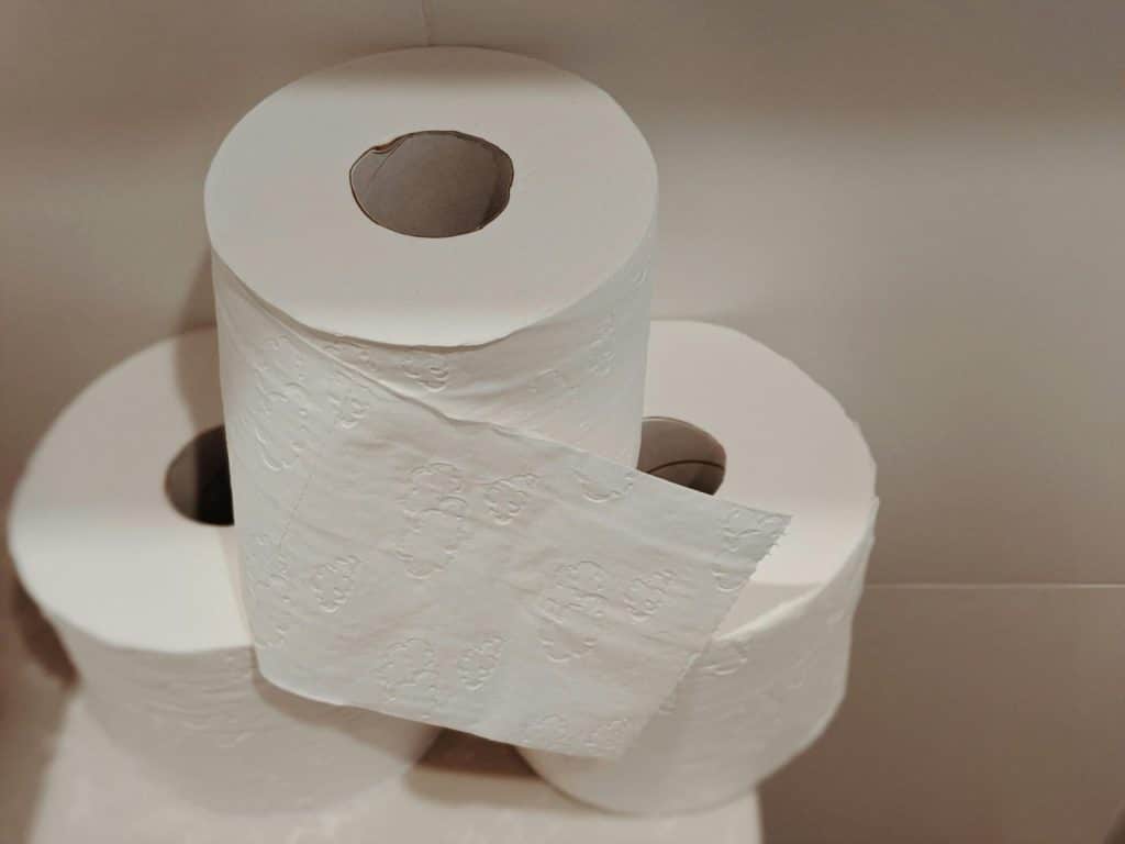 A neatly stacked pile of white toilet paper rolls, ideal for bathroom essentials and hygiene supplies.