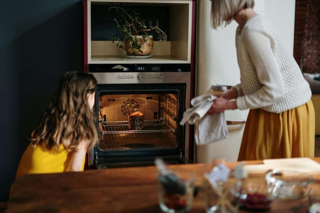 A mother and daughter enjoy quality time baking an Easter cake together in the kitchen.