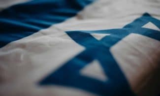 Detail of the Israeli national flag highlighting the Star of David, emphasizing its cultural significance.