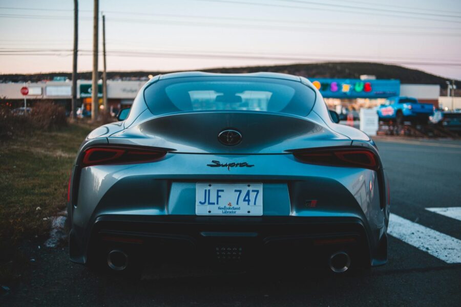 Rear view of a Toyota Supra parked on a roadside during twilight in an urban area.