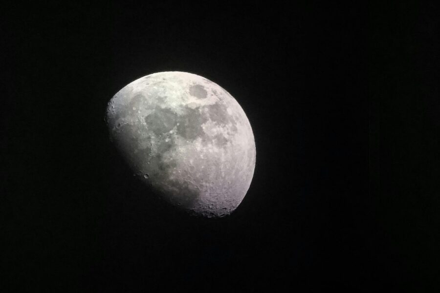 Stunning close-up of the half moon captured in a dark night sky, showcasing lunar craters and surface details.