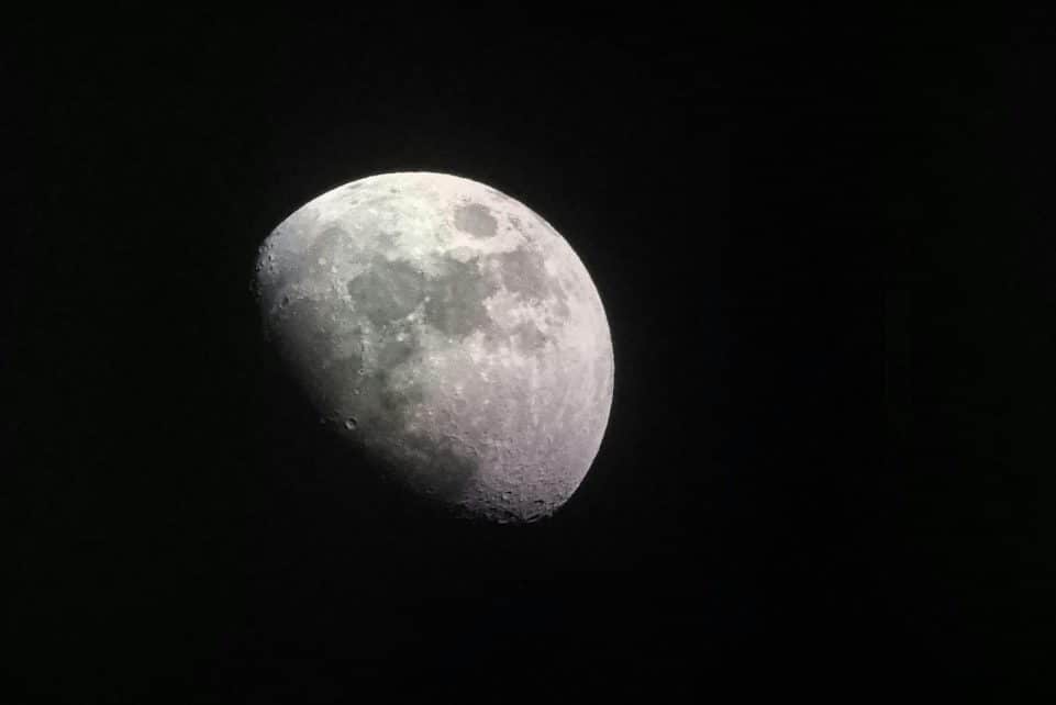 Stunning close-up of the half moon captured in a dark night sky, showcasing lunar craters and surface details.