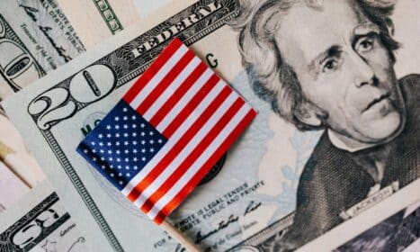 From above of small American flag placed on stack of 20 dollar bills as national currency for business financial operations