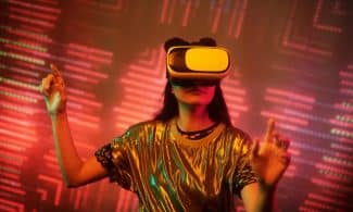 Woman in a metallic top using a virtual reality headset immersed in a digital environment with vibrant lights.