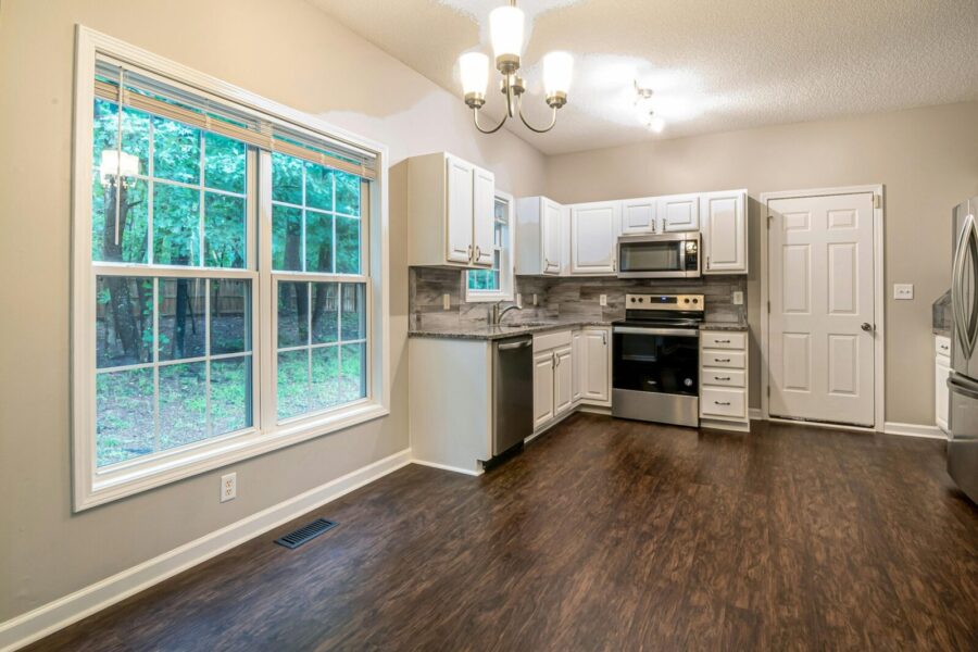 Spacious kitchen featuring modern appliances, large windows, and stylish cabinetry.