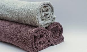 Close-up of rolled bathroom towels in neutral tones, ideal for interior design or spa themes.