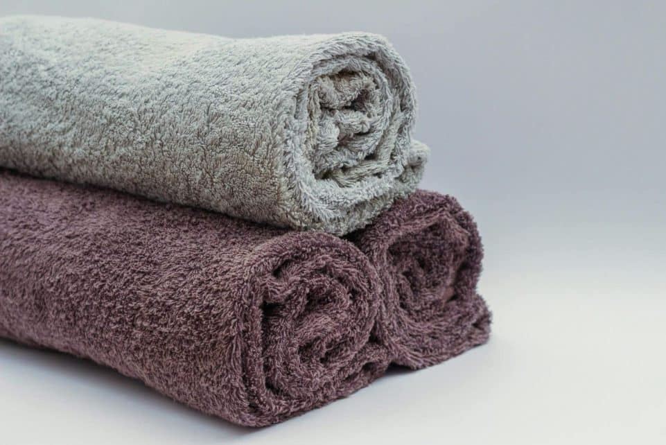 Close-up of rolled bathroom towels in neutral tones, ideal for interior design or spa themes.