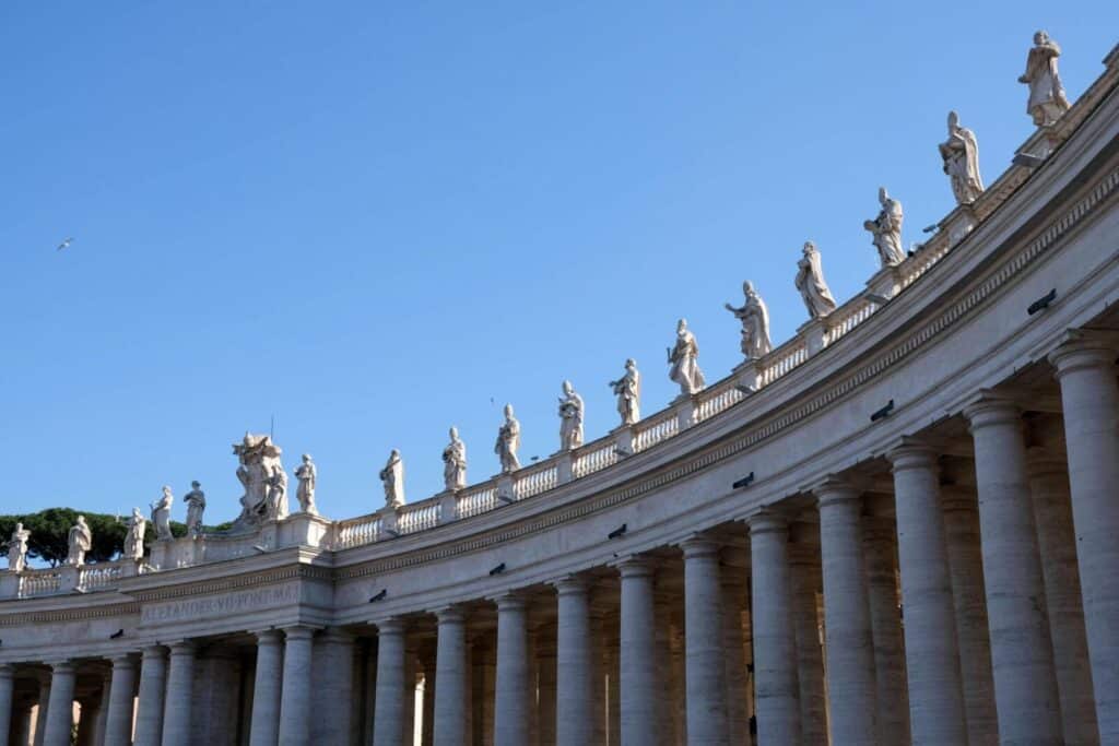 Elegant colonnade of St. Peter's Basilica in Vatican City showcasing historic sculptures.