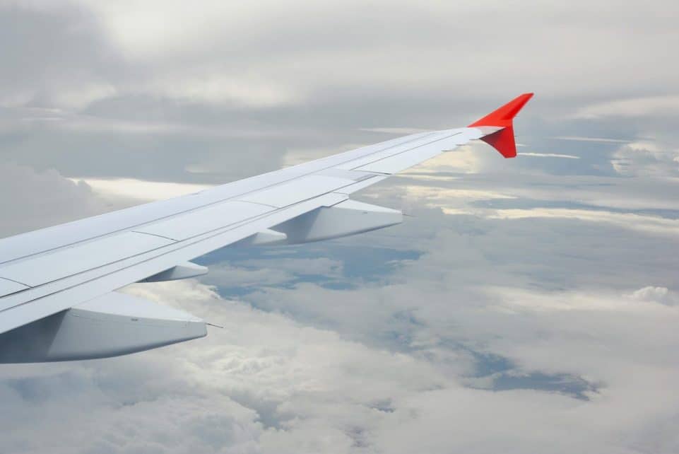 View from a plane window showing the wing against a cloudy sky.
