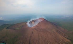 A stunning aerial shot capturing Telica Volcano's dramatic landscape and smoke plume in Nicaragua.
