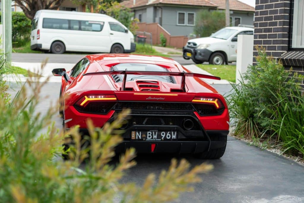 A stunning red Lamborghini Aventador parked in a residential driveway in Sydney, Australia.