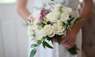 A beautiful bridal bouquet featuring white and pink roses, perfect for a wedding ceremony.