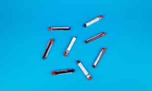 Multiple blood sample tubes arranged on a vivid blue background.