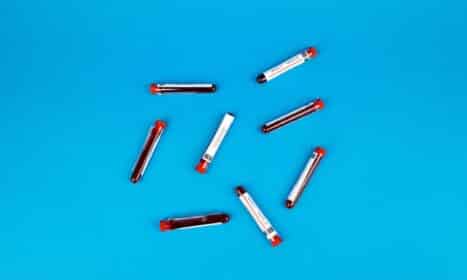 Multiple blood sample tubes arranged on a vivid blue background.