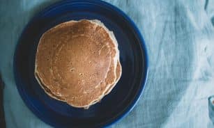 Aerial view of homemade pancakes on a blue plate, ready for breakfast.