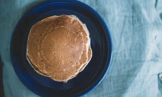 Aerial view of homemade pancakes on a blue plate, ready for breakfast.