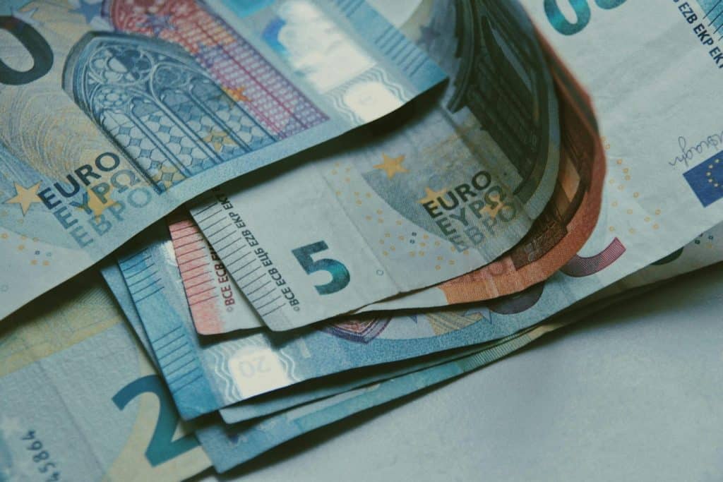 Detailed close-up of various Euro banknotes on a white surface, perfect for finance-related content.