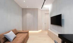 Sleek modern living room featuring a brown sofa and wall-mounted TV.