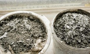 Two buckets filled with ash and debris, possibly from construction or cleanup.
