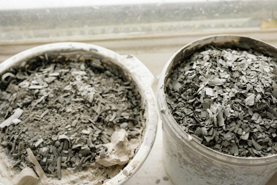 Two buckets filled with ash and debris, possibly from construction or cleanup.