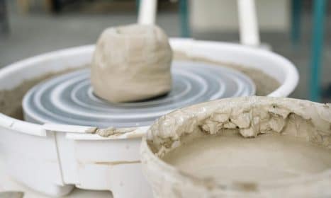 A detailed view of wet clay on a pottery wheel, highlighting the craftsmanship involved in pottery making.