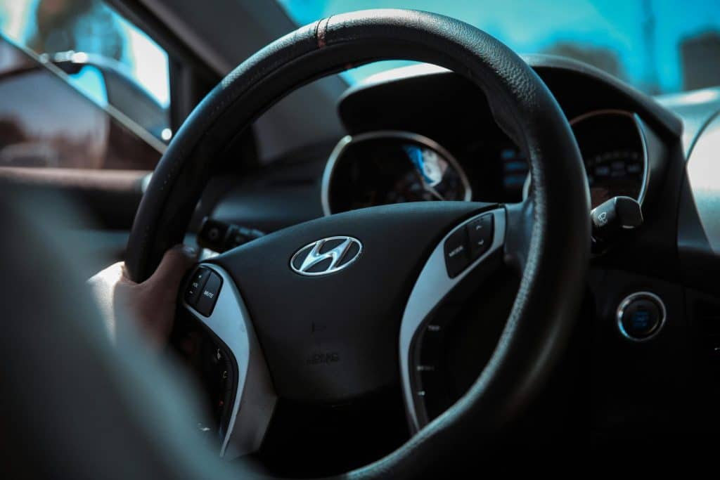 Detailed shot of a Hyundai steering wheel with dashboard in focus, interior view.