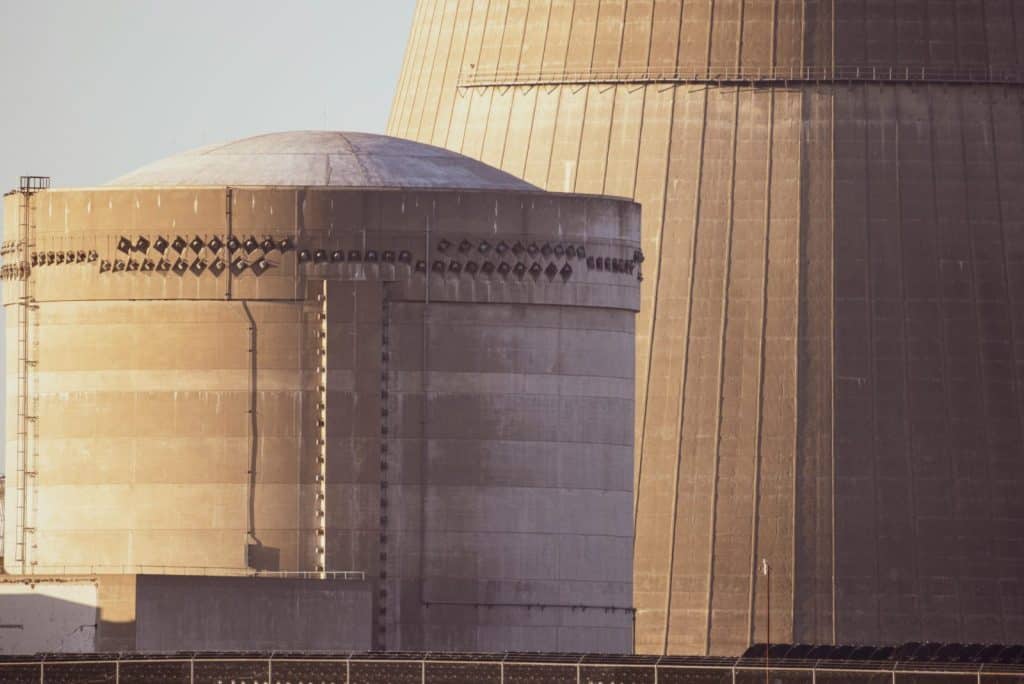 Close-up view of nuclear reactor buildings bathed in golden light, showcasing industrial architecture.