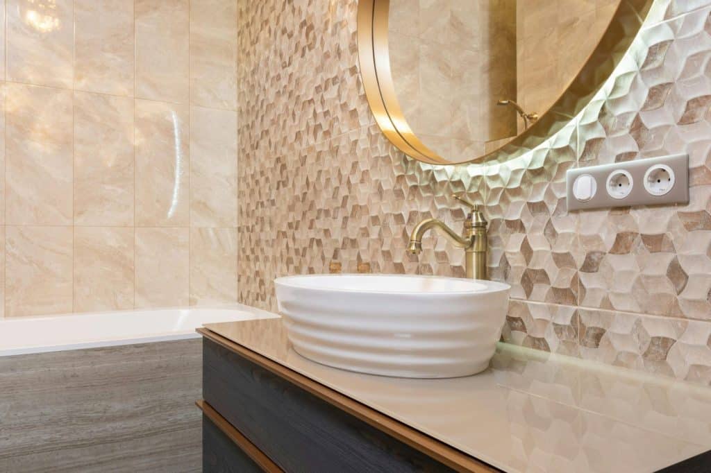 Elegant and contemporary bathroom featuring a unique patterned wall and luxurious fixtures.