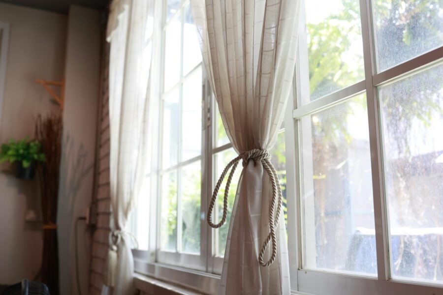 Soft tied curtains filtering sunlight through a window in an elegant indoor setting.