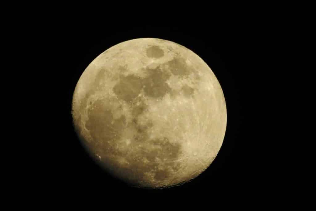 Detailed photograph of a full moon set against a dark night sky, highlighting lunar features.