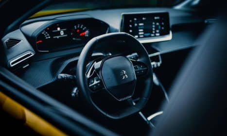 Close-up of a sleek car interior showcasing a modern steering wheel and dashboard design.