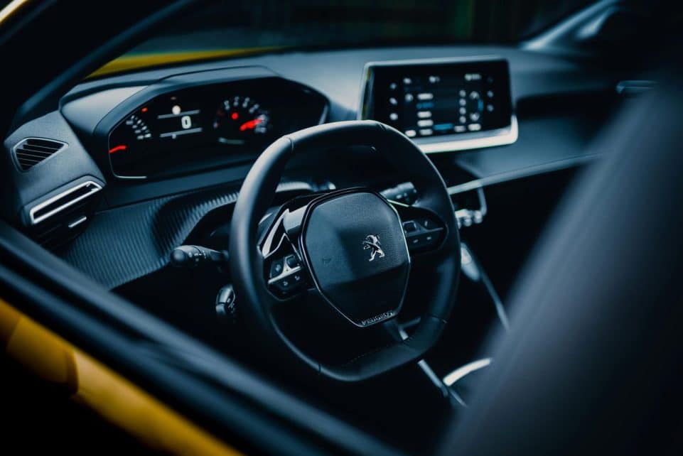 Close-up of a sleek car interior showcasing a modern steering wheel and dashboard design.