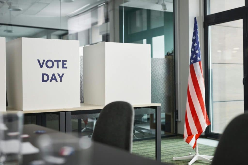 Voting booths with an American flag in an office, symbolizing Election Day.