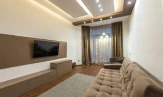 Spacious living room featuring modern design with cozy furniture and warm lighting.
