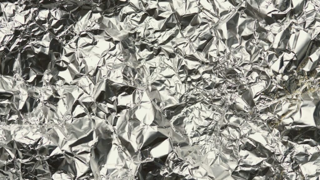 Close-up of crinkled silver foil with shiny texture, perfect for backgrounds or design elements.