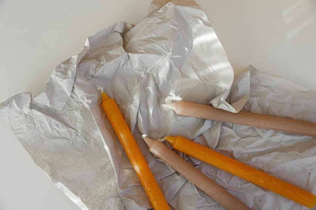 A collection of colorful candles resting on crumpled paper, perfect for creative projects.