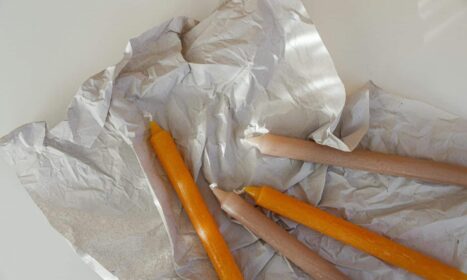 A collection of colorful candles resting on crumpled paper, perfect for creative projects.