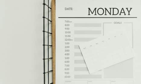 Top view of a minimalist schedule planner with Monday header. Perfect for organizing daily tasks with goals section.