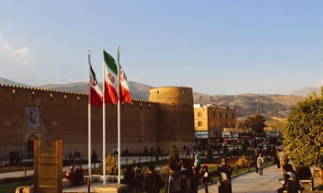 Karim Khan Citadel with Iranian flags in Shiraz, Iran at sunset.