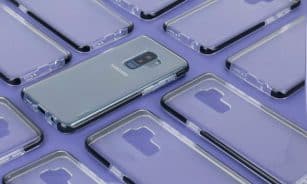 Close-up of a Samsung phone surrounded by transparent cases on a purple surface, showcasing modern technology.