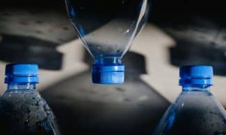 Artistic close-up of plastic bottles casting intricate shadows on a surface.