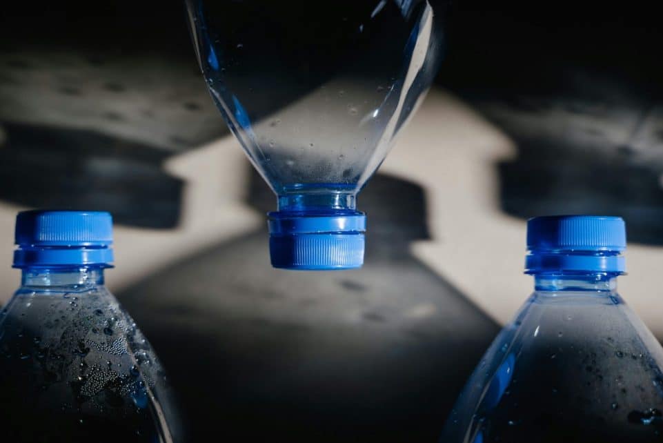 Artistic close-up of plastic bottles casting intricate shadows on a surface.