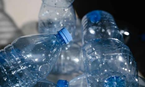 Multiple empty plastic bottles with water droplets in a close-up shot, highlighting recycling.