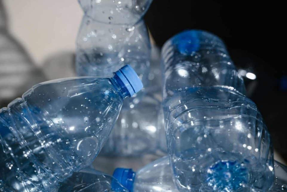 Multiple empty plastic bottles with water droplets in a close-up shot, highlighting recycling.