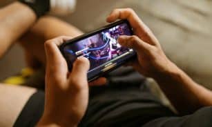 A person playing a mobile video game on a smartphone, focusing on gaming and technology lifestyle.